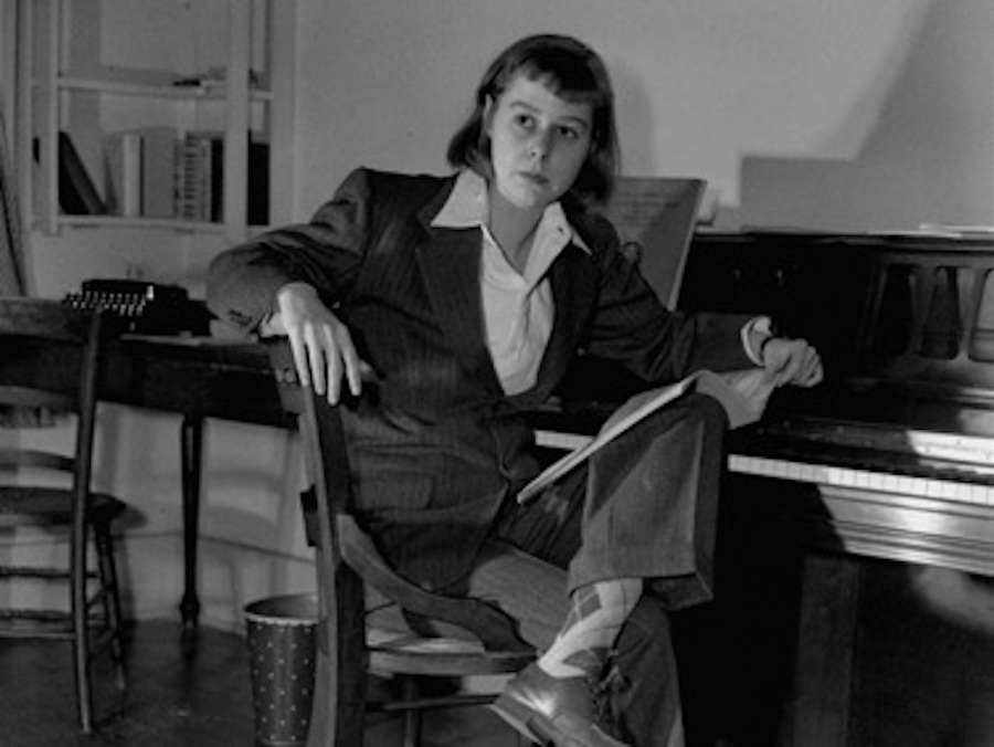 Carson McCullers at piano with crossed legs